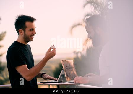 Two young entrepreneur men having a business talk while working online with their tablets Stock Photo