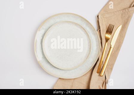 Empty plate and fork and knife with napkin on white background. Table setting. Top view, flat lay. Stock Photo