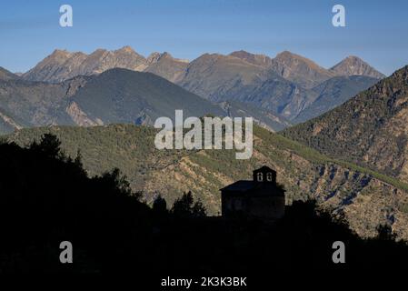 Romanesque church of Santa Eulàlia de Alendo, in the Alt Pirineu natural park, with the mountains of the Aigüestortes i Estany de Sant Maurici Park Stock Photo