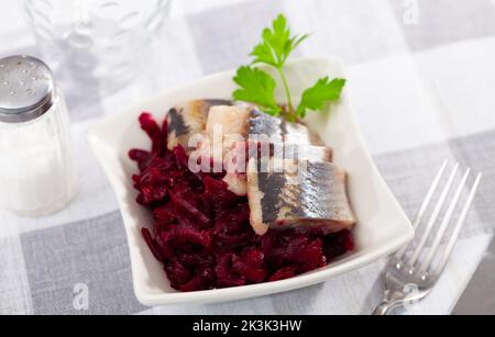 Sliced herring with grated beetroot served on table Stock Photo