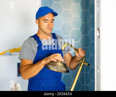 Plumbing specialist assembling tubes of shower in bathroom Stock Photo