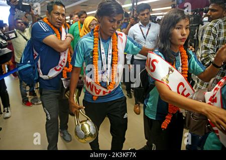 Bangladesh Women Football Team Captain Sabina Khatun (C) along Bangladesh Football Federation officials and teammates hold the trophy as they arrived Stock Photo