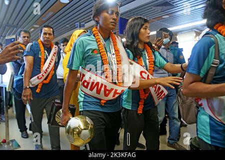 Bangladesh Women Football Team Captain Sabina Khatun (C) along Bangladesh Football Federation officials and teammates hold the trophy as they arrived Stock Photo