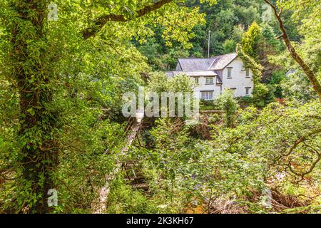 A glimpse of the village of Rockford from The Coleridge Way beside the East Lyn River on Exmoor National Park, Rockford, Devon UK Stock Photo