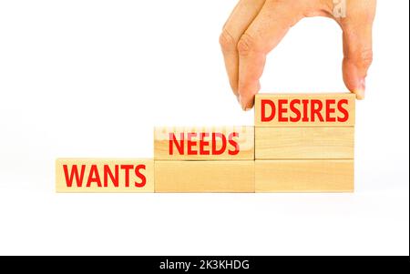 Wants needs and desires symbol. Concept words Wants Needs Desires on wooden blocks. Businessman hand. Beautiful white background. Business, psychologi Stock Photo