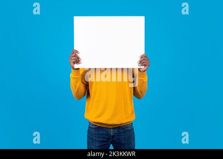 Unrecognizable african american guy hiding behind empty board Stock Photo