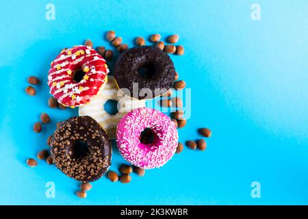 Donut with hazelnuts on blue background, close up Stock Photo