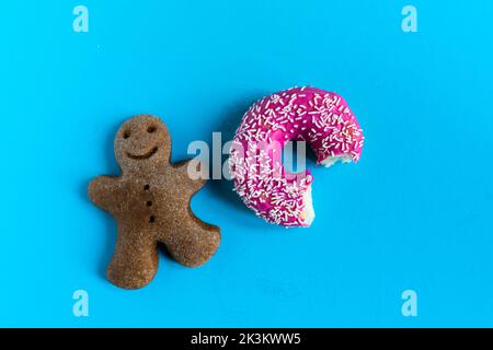 Donut with hazelnuts on blue background, close up Stock Photo