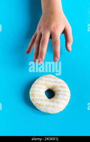Donut with hazelnuts on blue background, close up Stock Photo