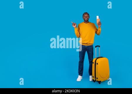 Happy black man having journey, pointing at copy space Stock Photo
