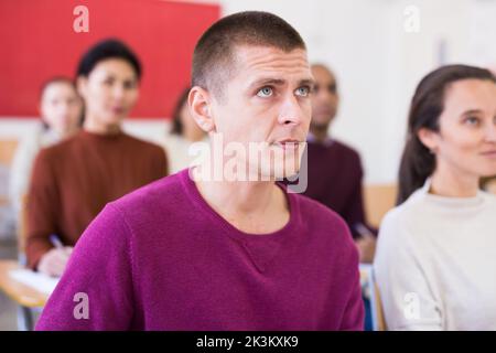 European man with other adult students in studying with colleagues Stock Photo