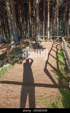 La Garganta forest Wooden Handrail. Trekker  shadow visible. He is using his hand as a visor. Extremadura, Spain Stock Photo