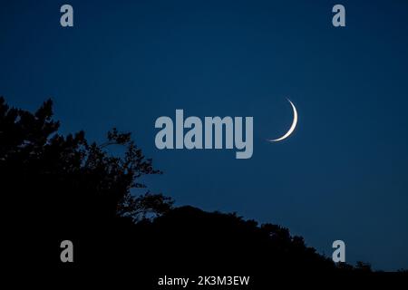 Crescent moon over hillside, Wales, UK Stock Photo