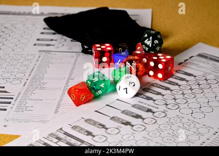 Game of dice to play role-playing of different colors on a table. Stock Photo