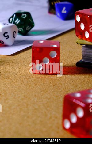 Several role-playing game dice with a role-playing character token, on top of a table. Stock Photo