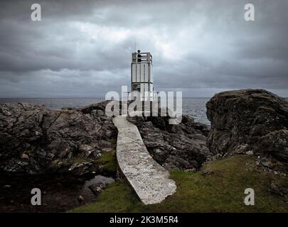 The lighthouse with concrete path running through folded rocks at the Point of Sleat, Sleat, Isle of Skye, Scotland. Stock Photo