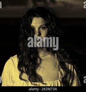 A mysterious portrait of a young woman at night with hair blowing in the wind Stock Photo