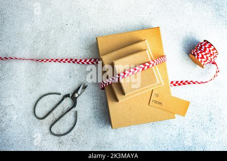From above Christmas gift boxes with bright red and white ribbon on concrete background Stock Photo