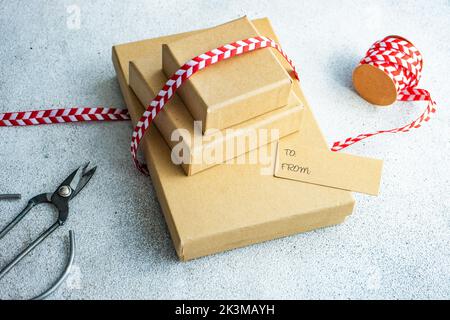 From above Christmas gift boxes with bright red and white ribbon on concrete background Stock Photo