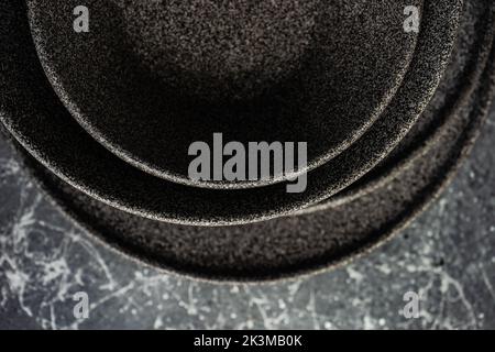 From above stone plates and bowls arrange in abstract geometric forms on concrete background Stock Photo