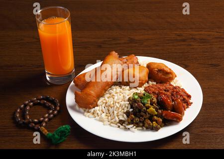 Ramadan Kareem and iftar muslim food, holiday concept. Trays with nuts and dried fruits and latterns with candles. Stock Photo