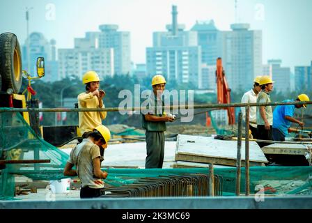 Beijing, CHINA- Small Group People, Chinese Migrant Workers, Men Working on Road  Construction Site Near Beijing Olympics Sports Stadium Stock Photo