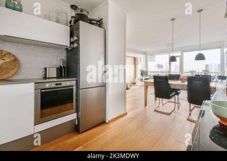 Modern kitchen with cabinets and sink in house with open plan dining room Stock Photo