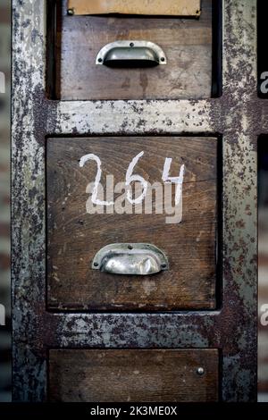 Vintage shabby wooden cabinet with rusty metal edges and handles in traditional barbershop Stock Photo