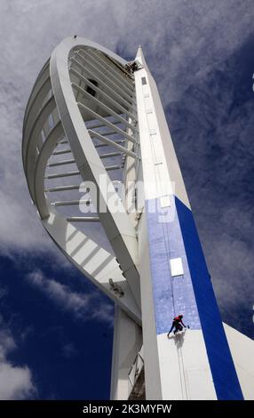 High roller Irina Gola has been making a splash with several thousands of litres of paint while she carries out a towering job with a difference – turning the tallest building outside London from white to blue and gold.     Irina is part of an army of painters drafted in to transform the 560ft high Spinnaker Tower in Port  smouth into the colours of new sponsors, Emirates Airlines.     The colouring has been the subject of controversy because the airline’s colours are gold and red and the tower was to have been painted red and gold until an online protest petition gathered 10,000 signatures. E Stock Photo