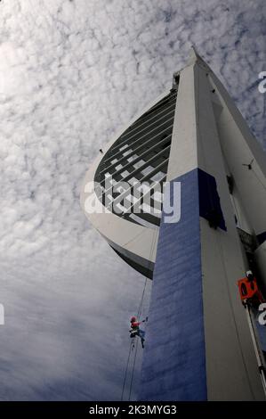 High roller Irina Gola has been making a splash with several thousands of litres of paint while she carries out a towering job with a difference – turning the tallest building outside London from white to blue and gold.     Irina is part of an army of painters drafted in to transform the 560ft high Spinnaker Tower in Port  smouth into the colours of new sponsors, Emirates Airlines.     The colouring has been the subject of controversy because the airline’s colours are gold and red and the tower was to have been painted red and gold until an online protest petition gathered 10,000 signatures. E Stock Photo