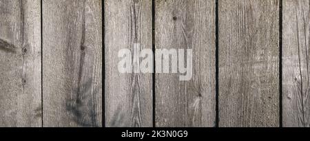 Wooden texture with horizontal lines. The texture of wood with knots and holes. The background of a wooden fence damaged by time. Banner of an old wooden fence. Stock Photo