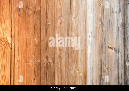 Wooden texture with vertical lines. The texture of wood with knots and holes. The background is made of a wooden fence of natural color. Red wooden background. Stock Photo