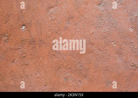The texture of old painted concrete. The concrete background is dusty pink. The background of a painted wall with cracks. Stock Photo