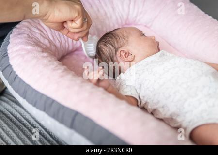 unrecognizable man's hand with ring combing a baby Stock Photo