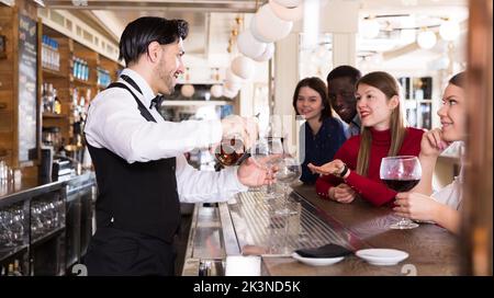 Bartender pouring beverages in bar Stock Photo