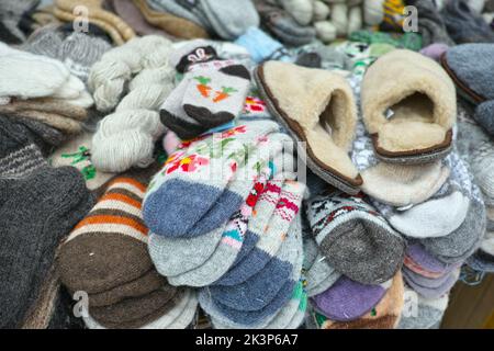 sale of handmade multi-color warm wool socks and slippers displayed outdoor Stock Photo