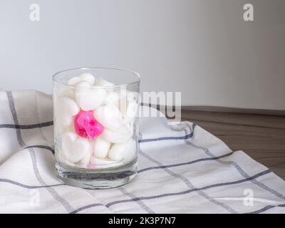White Ice cubes made from milk in heart shape with one red heart in glass. Space for text. Valentines day breakfast eating, love concept. Stock Photo