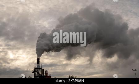 Smoking chimneys of a chemical plant emitting huge amounts of greenhouse gases.Air environment pollution concept Stock Photo
