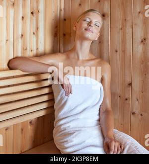 Refreshed and relaxed. A cropped shot of a beautiful young woman relaxing in the sauna. Stock Photo