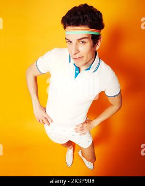 Retro behaviour. A caucasian male dressed in retro gym wear looking at the camera with his hands on his hips. Stock Photo