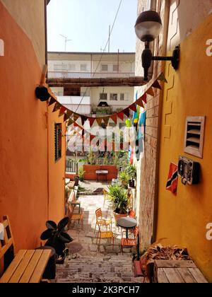 A vertical shot of a narrow street between old houses in Scalea village ...