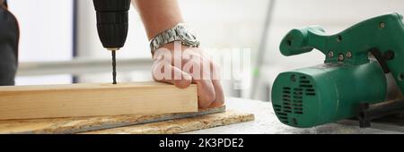 Workers instruments for repairing, man drill hole in wooden plank Stock Photo