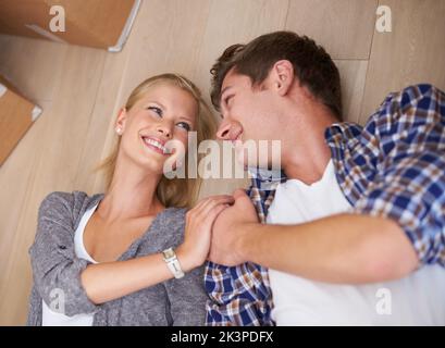 Exhausted after a day of moving. a couple lying on the floor happily after a long day of moving house. Stock Photo