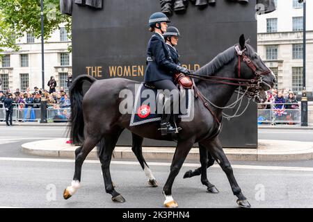 two mounted Met police officers riding horses through chinatown soho ...