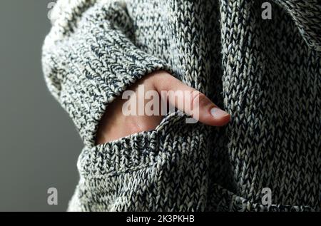 close-up of young woman in warm wool cardigan preparing for cold winter with gas and electricity shortage due to Russia Ukraine war Stock Photo
