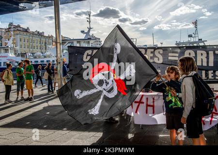 Marseille, France. 27th Sep, 2022. Protesters hold a pirate flag with a skull and crossbones during the demonstration. Anti-cruise and sustainable tourism activists demonstrate under the shade of the Old Port denouncing the nuisance and pollution of cruise ships calling in the city. (Photo by Laurent Coust/SOPA Images/Sipa USA) Credit: Sipa USA/Alamy Live News Stock Photo