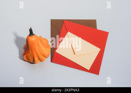 Colorful envelopes and pumpkin on a table. Autumn concept. Top view, mockup. Stock Photo