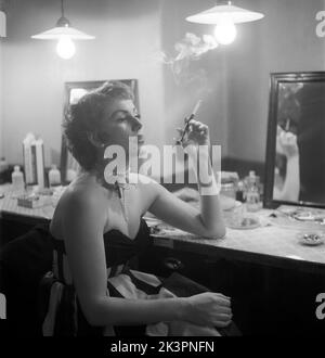 At the theatre in the 1950s. Actress dancer Karin Maria Elisabet Matisen, known as Topsy. A beautiful picture of her in her dressingroom behind the scenes where she looks glamourous smoking a cigarette.  Sweden 1952 Kristoffersson ref BH99-6 Stock Photo