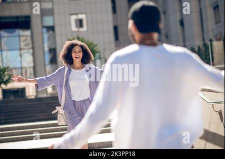Young people meeting in the street and looking excited Stock Photo