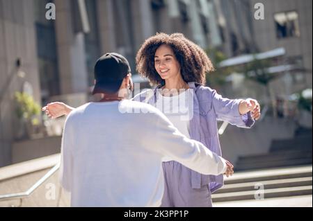 Young people meeting in the street and looking excited Stock Photo